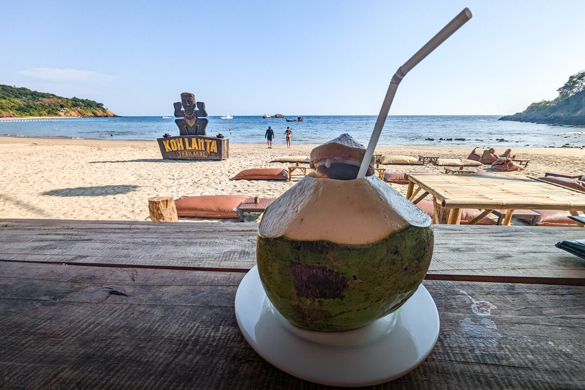 Boisson dans une noix de coco sur la plage à Koh Lanta